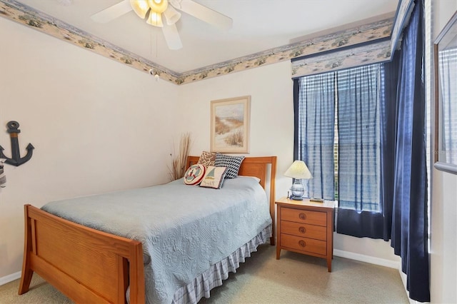 bedroom with ceiling fan, baseboards, and light colored carpet