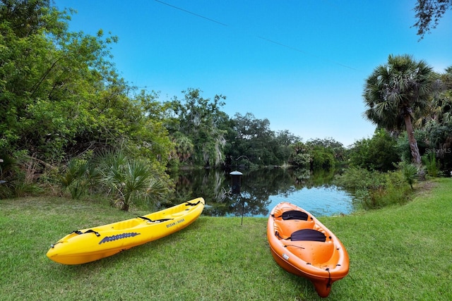 view of playground featuring a water view and a lawn