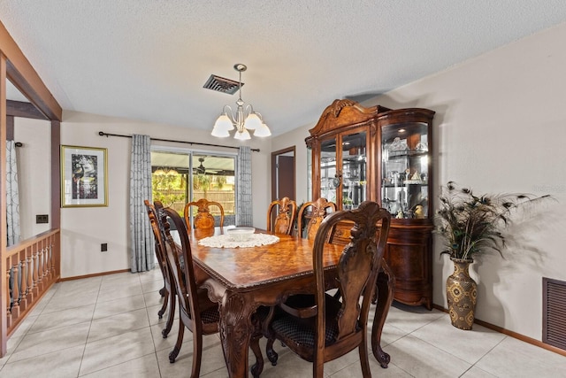 dining area featuring a chandelier, visible vents, light tile patterned flooring, and a textured ceiling