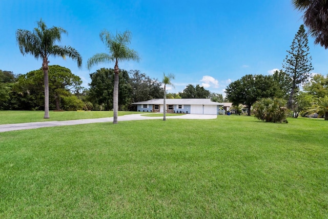 view of yard featuring driveway and a garage