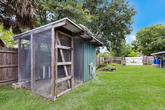 view of poultry coop featuring a fenced backyard and a lawn