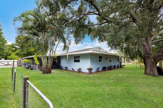 exterior space with stucco siding, fence, and a yard