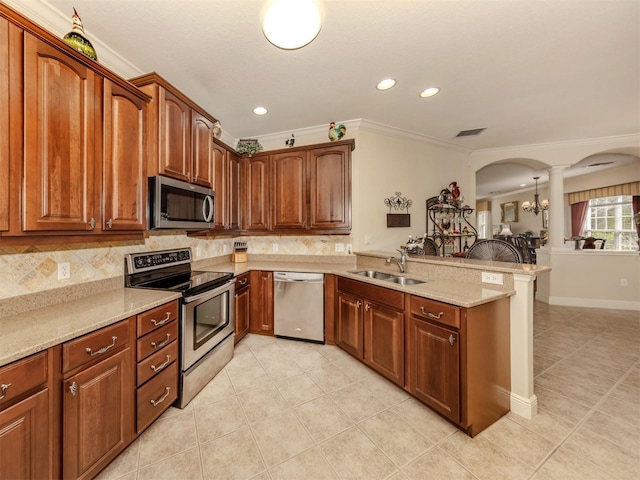 kitchen with arched walkways, a breakfast bar area, stainless steel appliances, a peninsula, and a sink