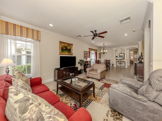 living area with arched walkways, tile patterned floors, visible vents, and crown molding