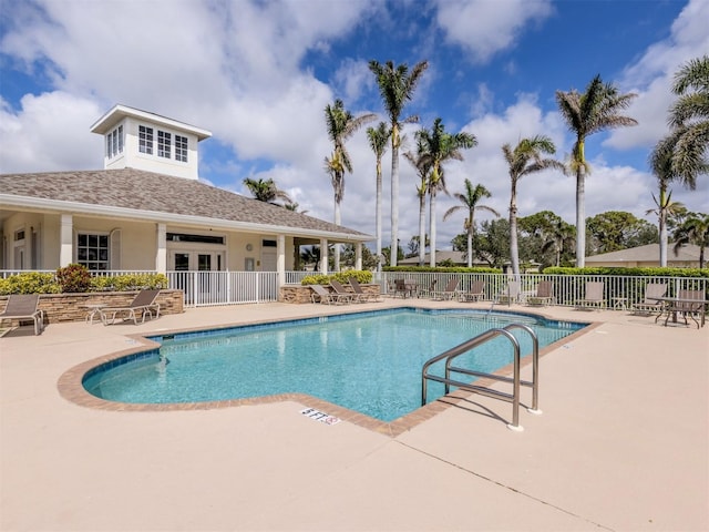 pool with a patio area and fence