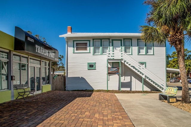 view of front of home with stairs, french doors, and a chimney