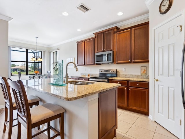1425 Maseno Dr, Venice, FL 34292 - kitchen featuring appliances with stainless steel finishes, a sink, a kitchen breakfast bar, a kitchen island with sink, and light stone countertops