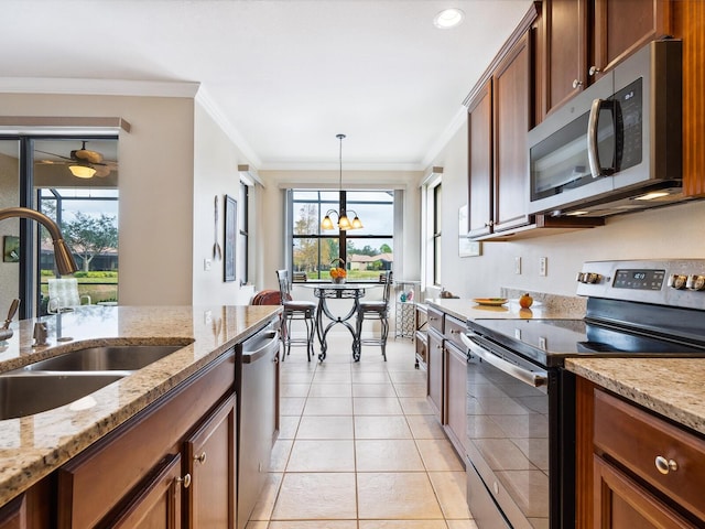 1425 Maseno Dr, Venice, FL 34292 - kitchen featuring stainless steel appliances, a sink, ornamental molding, hanging light fixtures, and light tile patterned floors