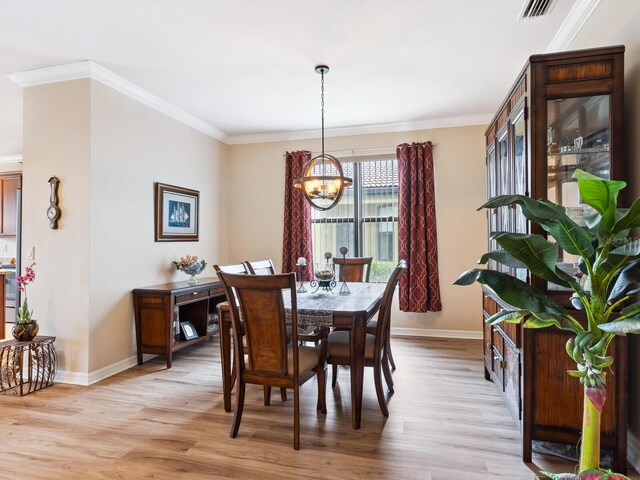 1425 Maseno Dr, Venice, FL 34292 - dining room with a chandelier, baseboards, crown molding, and light wood-style floors