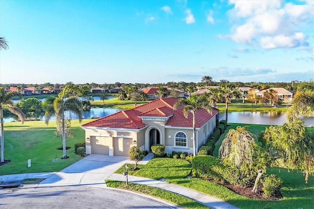 mediterranean / spanish-style home featuring a water view, driveway, a tiled roof, and stucco siding