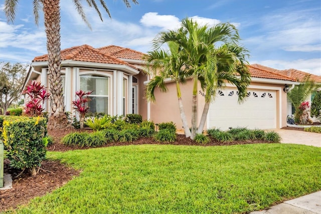 mediterranean / spanish-style house with a tile roof, stucco siding, a front yard, a garage, and driveway