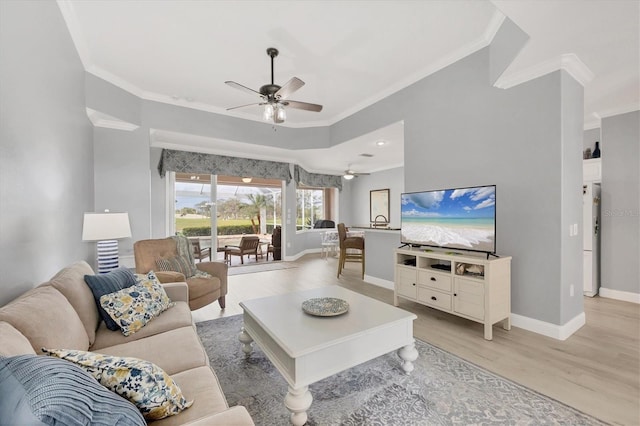 living area with light wood-style floors, crown molding, baseboards, and ceiling fan