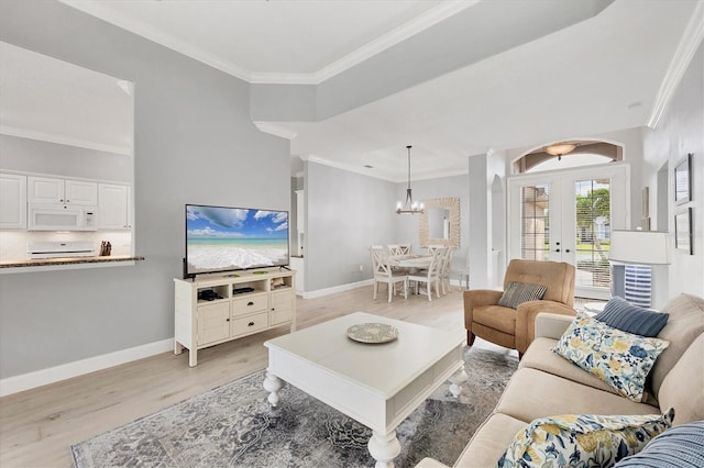 living area featuring baseboards, french doors, light wood-style flooring, and crown molding