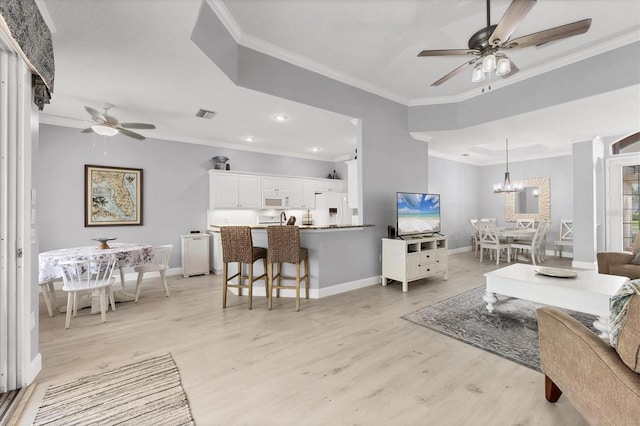 living room with light wood finished floors, baseboards, crown molding, and ceiling fan with notable chandelier