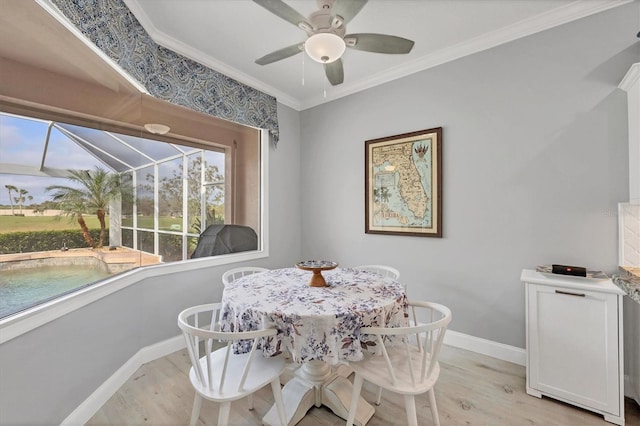 dining room featuring a sunroom, baseboards, light wood finished floors, and crown molding