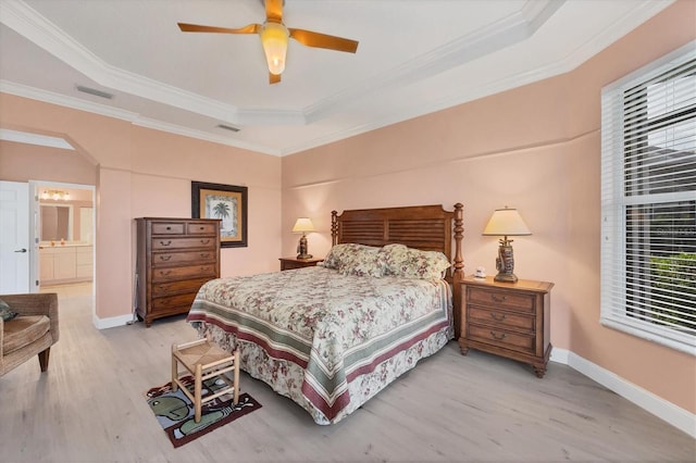 bedroom featuring light wood-style floors, a raised ceiling, and visible vents