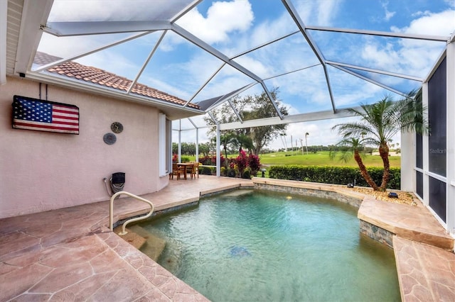 outdoor pool featuring glass enclosure and a patio