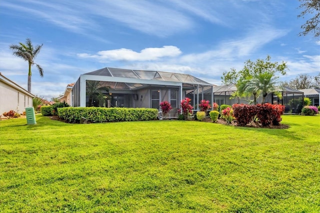 back of property with glass enclosure and a lawn