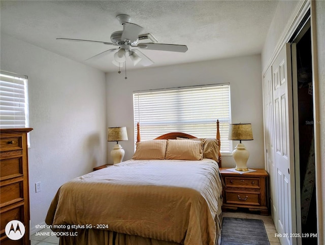 bedroom featuring a closet, multiple windows, a ceiling fan, and a textured ceiling