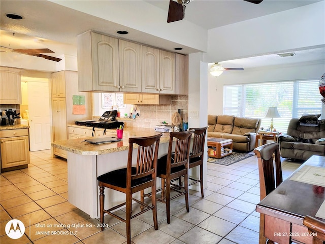 kitchen with light tile patterned floors, ceiling fan, visible vents, and open floor plan