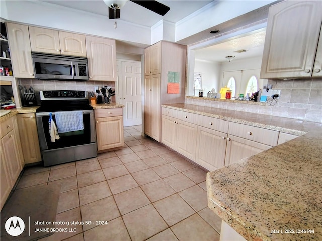 kitchen with light tile patterned floors, backsplash, light brown cabinetry, appliances with stainless steel finishes, and ceiling fan