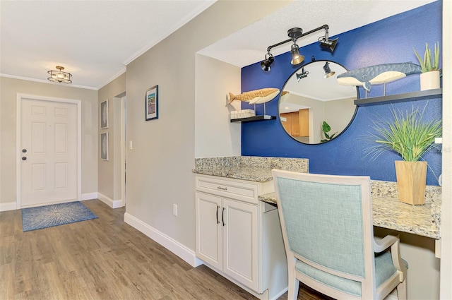 interior space with baseboards, ornamental molding, light wood-style floors, white cabinetry, and open shelves