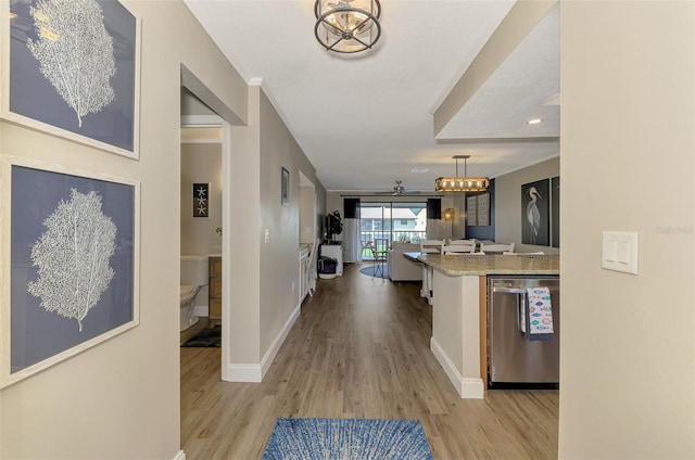 interior space featuring a chandelier, baseboards, and light wood finished floors