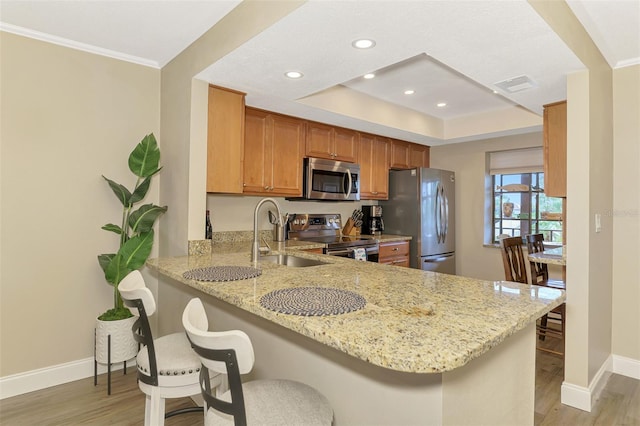 kitchen featuring a peninsula, stainless steel appliances, and a kitchen breakfast bar