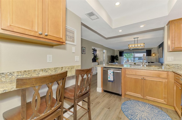 kitchen with light wood finished floors, open floor plan, a sink, dishwasher, and a peninsula