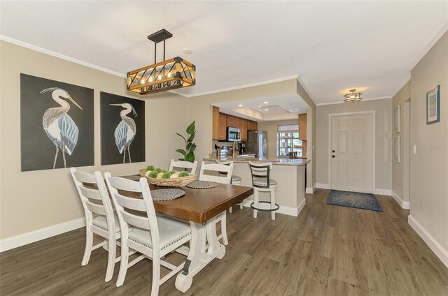 dining space featuring ornamental molding, dark wood-style flooring, and baseboards