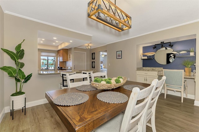 dining space featuring light wood finished floors, baseboards, ornamental molding, and recessed lighting