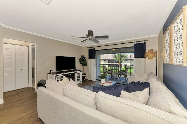 living room with ornamental molding, ceiling fan, baseboards, and wood finished floors