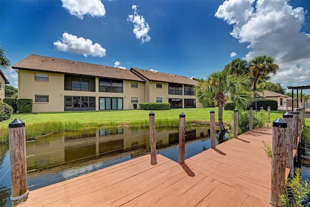 dock area featuring a water view and a lawn