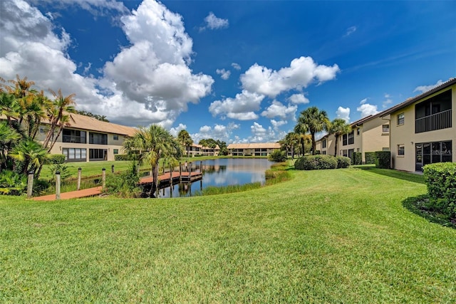 dock area featuring a water view and a lawn