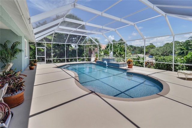 pool featuring glass enclosure and a patio