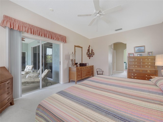 bedroom with arched walkways, access to outside, carpet flooring, and visible vents