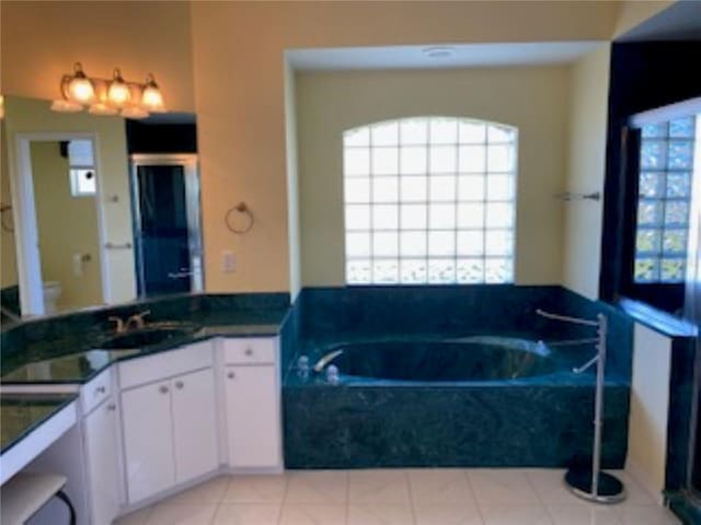 full bath featuring tile patterned floors, a sink, toilet, and a bath