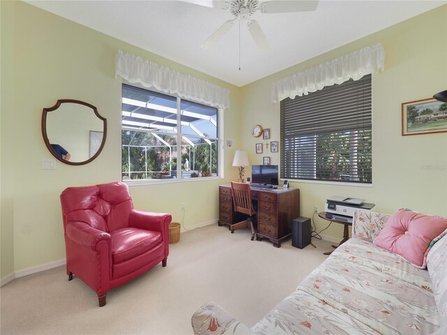 carpeted home office with baseboards and a ceiling fan