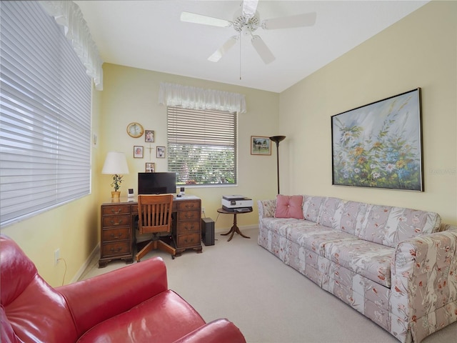 carpeted home office with ceiling fan and baseboards