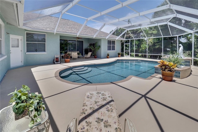 pool featuring a patio, glass enclosure, and a ceiling fan