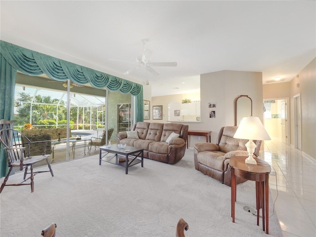 living room with a sunroom, ceiling fan, light colored carpet, and light tile patterned flooring