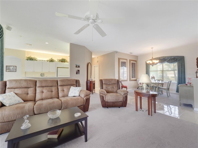 living room featuring light carpet, light tile patterned floors, and ceiling fan with notable chandelier