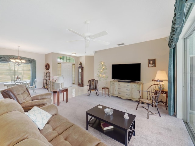 living room with ceiling fan with notable chandelier, visible vents, and light colored carpet