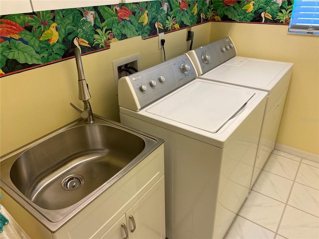 clothes washing area with tile patterned flooring, a sink, baseboards, cabinet space, and washer and clothes dryer