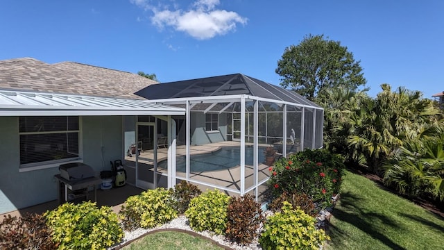 back of house featuring a patio, metal roof, roof with shingles, a lanai, and a standing seam roof