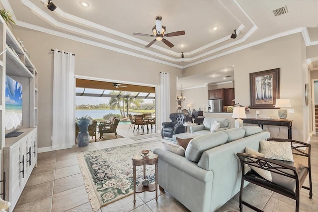 living room with a tray ceiling, visible vents, crown molding, and ceiling fan with notable chandelier