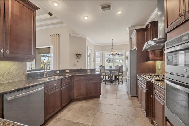 kitchen with a sink, visible vents, exhaust hood, appliances with stainless steel finishes, and dark countertops