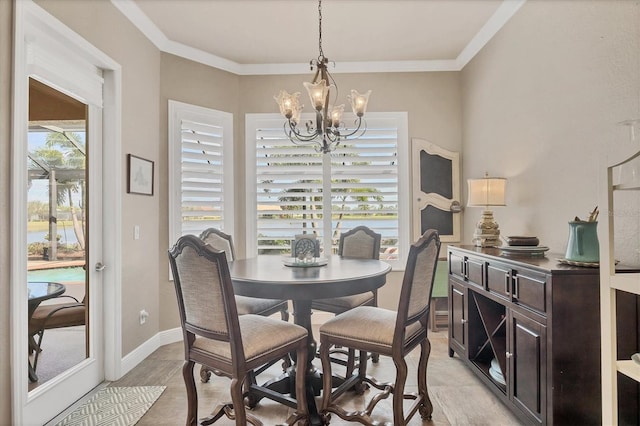 dining room featuring baseboards, a chandelier, and crown molding