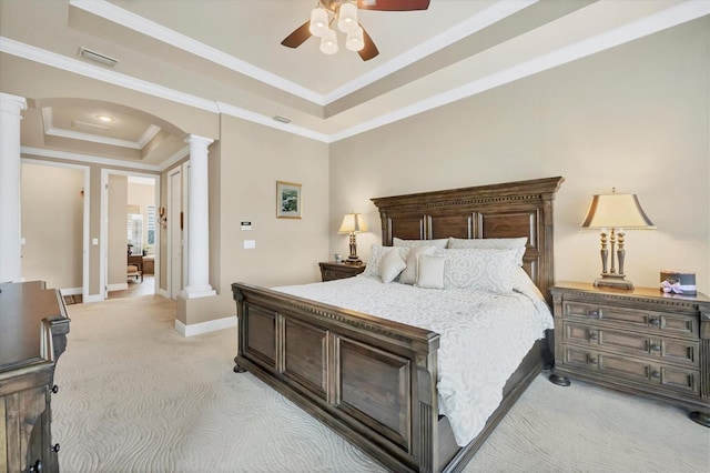 bedroom featuring a tray ceiling, arched walkways, decorative columns, light colored carpet, and visible vents