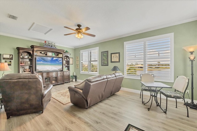 living room featuring ornamental molding, visible vents, and light wood-style floors